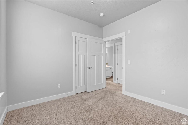 1816 W Eaglewood Dr Unit 101, Saratoga Springs, UT 84045 - unfurnished bedroom featuring baseboards, a textured ceiling, a closet, and carpet