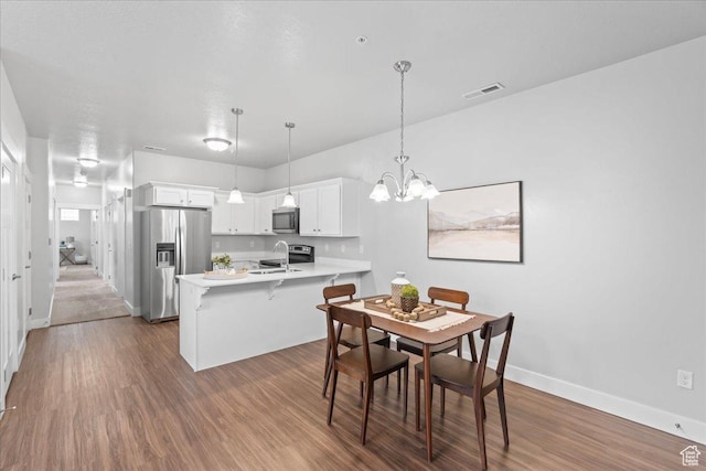 1816 W Eaglewood Dr Unit 101, Saratoga Springs, UT 84045 - dining space with dark wood-style flooring, a notable chandelier, baseboards, and visible vents