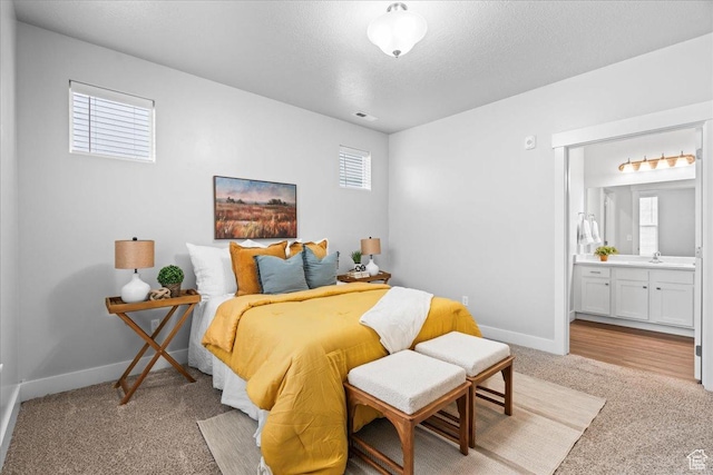 1816 W Eaglewood Dr Unit 101, Saratoga Springs, UT 84045 - bedroom with connected bathroom, light colored carpet, a textured ceiling, baseboards, and visible vents