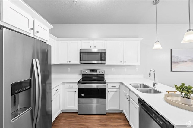 1816 W Eaglewood Dr Unit 101, Saratoga Springs, UT 84045 - kitchen featuring a sink, a peninsula, stainless steel appliances, white cabinets, and dark wood-style flooring