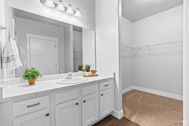 1816 W Eaglewood Dr Unit 101, Saratoga Springs, UT 84045 - bathroom featuring a spacious closet, vanity, and baseboards