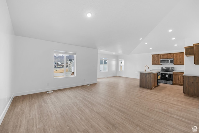 1651 E 900 N Unit 16, Spanish Fork, UT 84660 - unfurnished living room featuring baseboards, light wood-style floors, a sink, and lofted ceiling