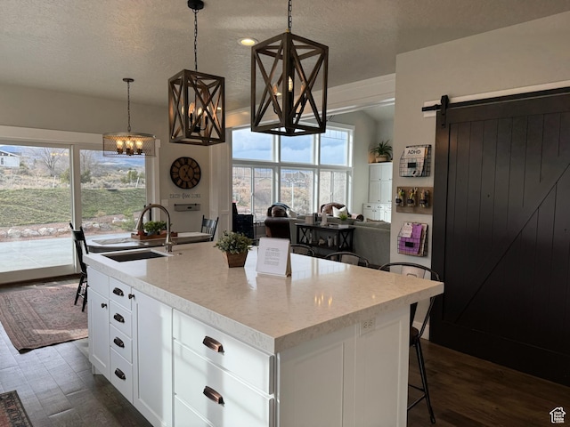 142 S 3500 W, Maeser, UT 84078 - kitchen with white cabinets, a sink, plenty of natural light, and a center island with sink
