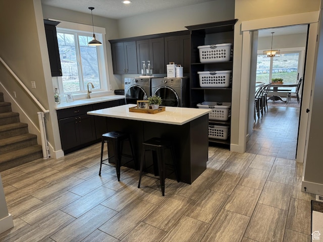 142 S 3500 W, Maeser, UT 84078 - kitchen featuring light countertops, decorative light fixtures, wood finish floors, washing machine and clothes dryer, and a sink