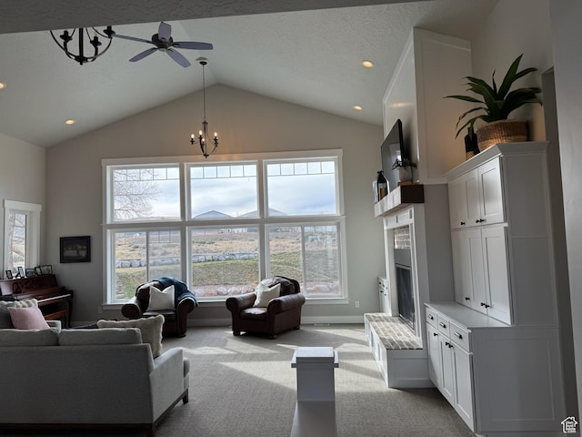 142 S 3500 W, Maeser, UT 84078 - carpeted living area featuring high vaulted ceiling, a fireplace with raised hearth, a textured ceiling, baseboards, and ceiling fan with notable chandelier