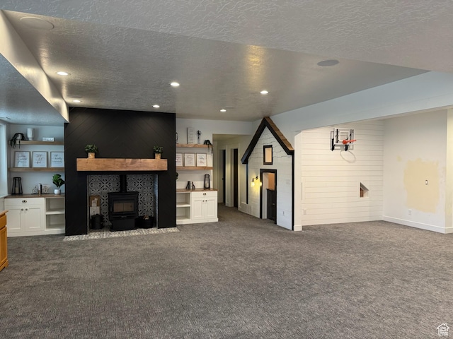 142 S 3500 W, Maeser, UT 84078 - unfurnished living room featuring dark carpet, a wood stove, recessed lighting, and a textured ceiling