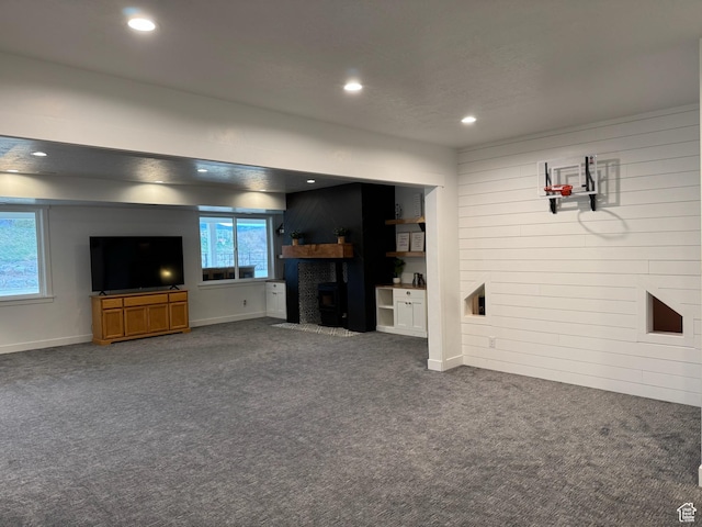 142 S 3500 W, Maeser, UT 84078 - unfurnished living room with a fireplace with flush hearth, wooden walls, baseboards, recessed lighting, and dark carpet