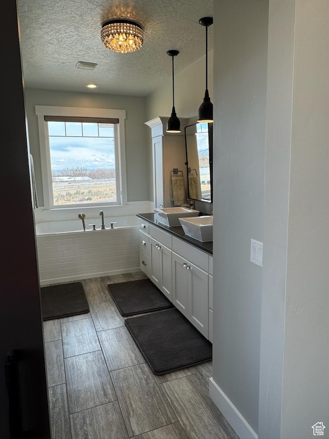 142 S 3500 W, Maeser, UT 84078 - full bath with a sink, a garden tub, a textured ceiling, wood finish floors, and double vanity