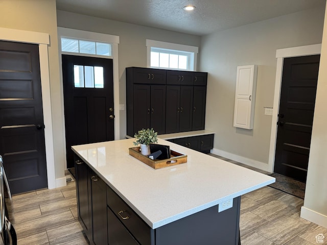 142 S 3500 W, Maeser, UT 84078 - kitchen featuring light countertops, a textured ceiling, a center island, baseboards, and dark cabinets