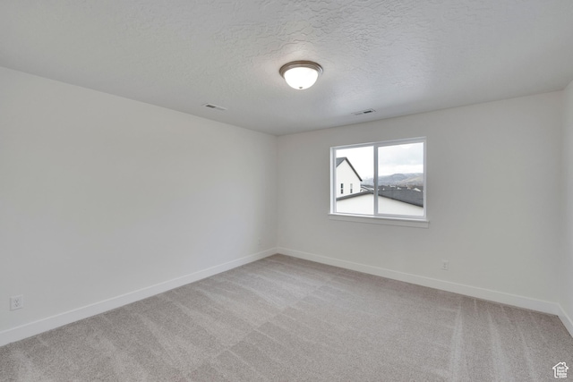 6161 W Teton Ranch Dr Unit 342, Herriman, UT 84096 - unfurnished room featuring baseboards, light carpet, and a textured ceiling