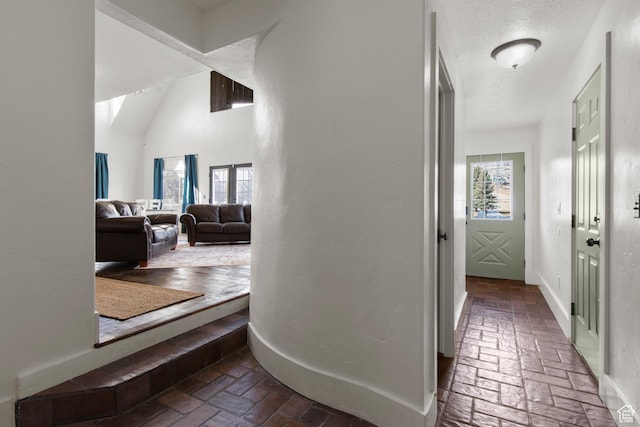 2599 S Foxridge Rd, Garden City, UT 84028 - hall featuring baseboards, brick floor, and a textured ceiling