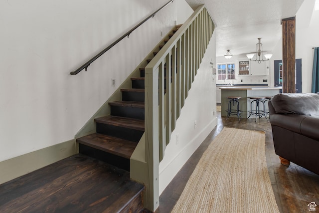2599 S Foxridge Rd, Garden City, UT 84028 - staircase featuring a notable chandelier and wood finished floors