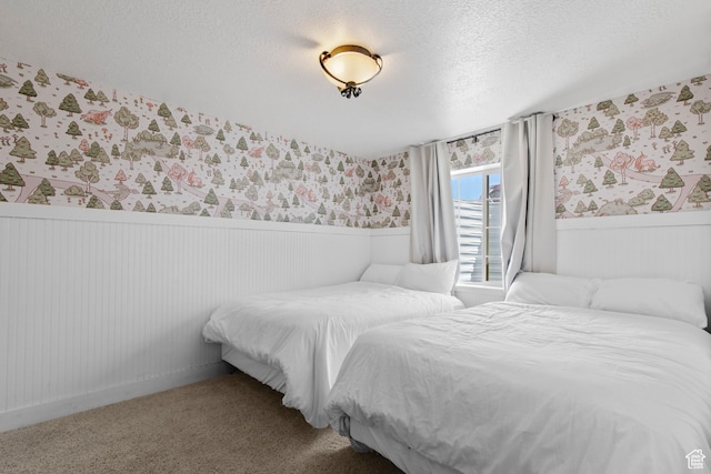 2599 S Foxridge Rd, Garden City, UT 84028 - bedroom with carpet, a textured ceiling, wallpapered walls, and wainscoting