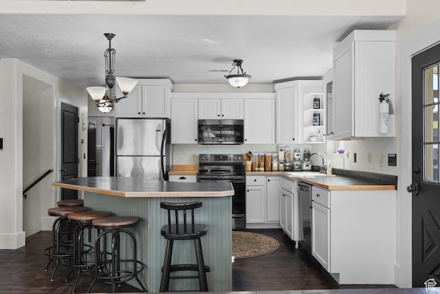 2599 S Foxridge Rd, Garden City, UT 84028 - kitchen featuring white cabinets, a breakfast bar, tasteful backsplash, appliances with stainless steel finishes, and a sink