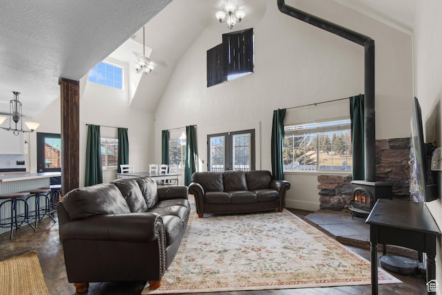 2599 S Foxridge Rd, Garden City, UT 84028 - living room featuring high vaulted ceiling, an inviting chandelier, a wood stove, and a healthy amount of sunlight