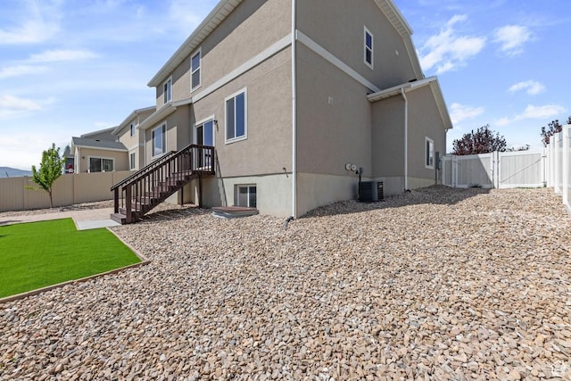 49 W Paper Bark St, Vineyard, UT 84059 - back of house with stucco siding, a gate, a fenced backyard, and cooling unit