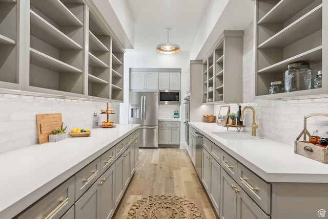 13042 N Prospector Way, Alpine, UT 84004 - kitchen featuring stainless steel appliances, a sink, gray cabinets, open shelves, and decorative backsplash