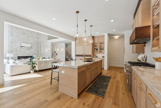 13042 N Prospector Way, Alpine, UT 84004 - kitchen featuring high end stainless steel range, a sink, a kitchen breakfast bar, light wood-type flooring, and custom range hood