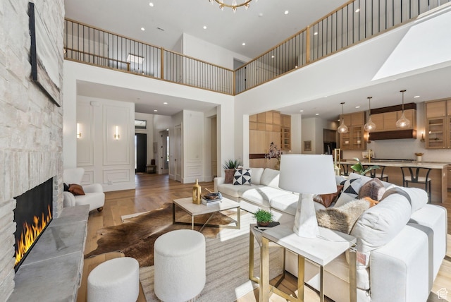 13042 N Prospector Way, Alpine, UT 84004 - living room with a high ceiling, a stone fireplace, light wood finished floors, and recessed lighting