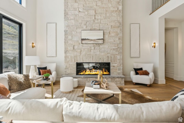 13042 N Prospector Way, Alpine, UT 84004 - living area featuring a fireplace, a high ceiling, wood finished floors, and baseboards