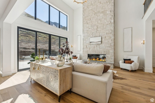 13042 N Prospector Way, Alpine, UT 84004 - living area with a high ceiling, wood finished floors, a stone fireplace, and baseboards