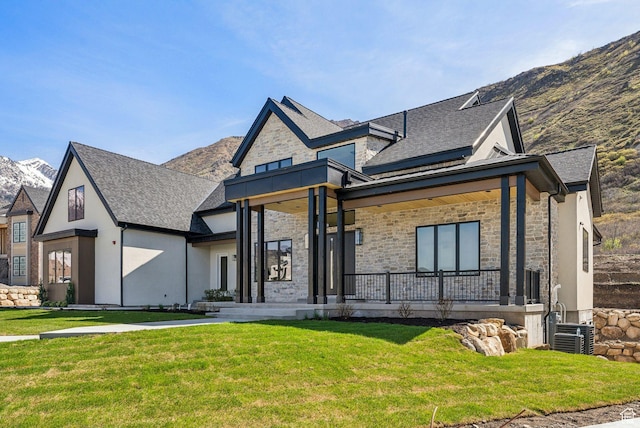 13042 N Prospector Way, Alpine, UT 84004 - view of front of home featuring stone siding, a front lawn, covered porch, and a mountain view