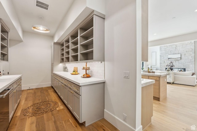 13042 N Prospector Way, Alpine, UT 84004 - bar area with light wood-type flooring, baseboards, tasteful backsplash, and stainless steel dishwasher