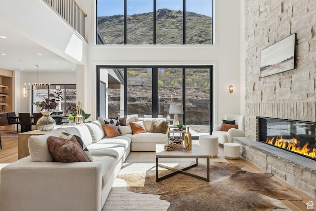 13042 N Prospector Way, Alpine, UT 84004 - living room featuring a high ceiling, wood finished floors, a stone fireplace, plenty of natural light, and a mountain view