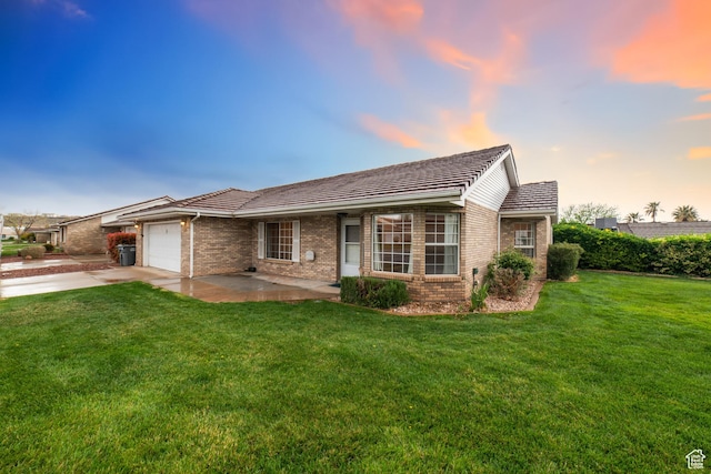 ranch-style home featuring brick siding, a garage, concrete driveway, and a yard