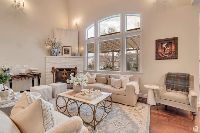 12483 N Timberline Dr, Highland, UT 84003 - living room featuring a towering ceiling, baseboards, a fireplace, and wood finished floors