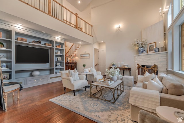 12483 N Timberline Dr, Highland, UT 84003 - living area with stairs, a fireplace, wood finished floors, built in shelves, and arched walkways