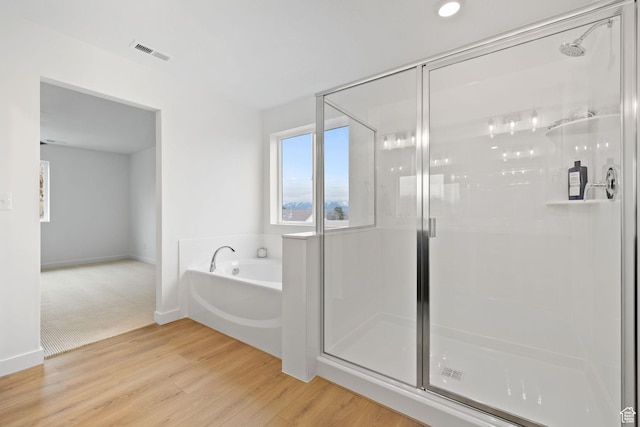 695 N Plainsman Dr Unit 110, Spanish Fork, UT 84660 - bathroom with a bath, wood finished floors, visible vents, and a stall shower