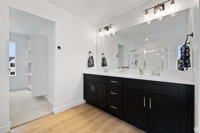 695 N Plainsman Dr Unit 110, Spanish Fork, UT 84660 - bathroom featuring a shower stall, wood finished floors, a sink, double vanity, and baseboards
