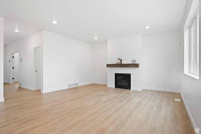 695 N Plainsman Dr Unit 110, Spanish Fork, UT 84660 - unfurnished living room with a glass covered fireplace, light wood-type flooring, baseboards, recessed lighting, and visible vents