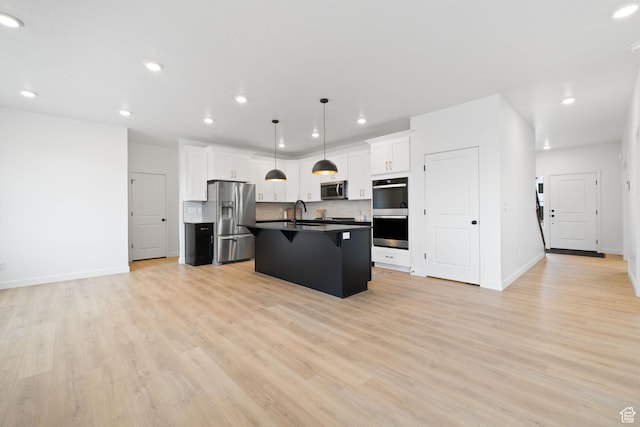695 N Plainsman Dr Unit 110, Spanish Fork, UT 84660 - kitchen featuring light wood-style flooring, white cabinets, a breakfast bar, appliances with stainless steel finishes, and dark countertops