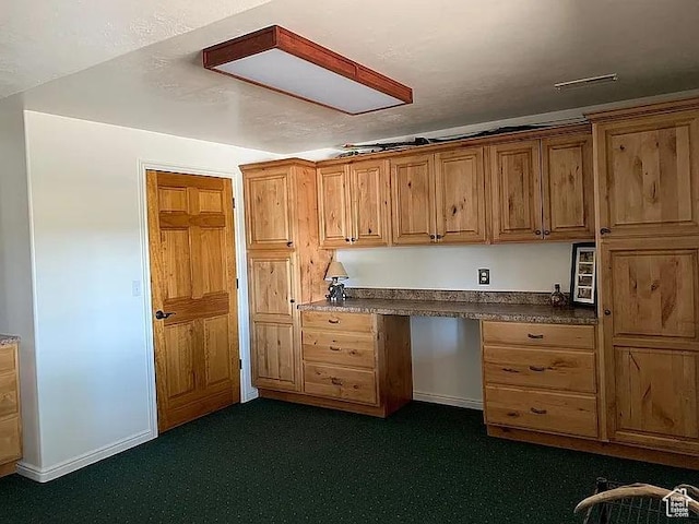 1345 W 1625 S, Price, UT 84501 - kitchen featuring built in study area, brown cabinets, baseboards, dark countertops, and dark carpet