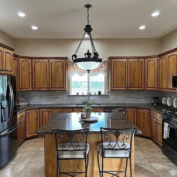 1345 W 1625 S, Price, UT 84501 - kitchen featuring a sink, black appliances, a breakfast bar, and tasteful backsplash
