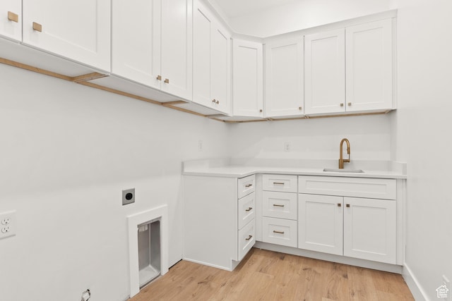 1522 N Zion Cir, Apple Valley, UT 84737 - laundry area with a sink, light wood finished floors, electric dryer hookup, baseboards, and cabinet space