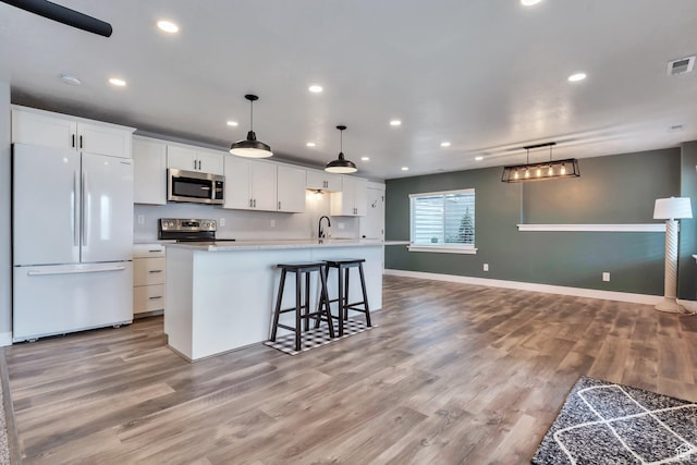 13907 S Birch Leaf W, Herriman, UT 84096 - kitchen featuring white cabinetry, a sink, light wood finished floors, a kitchen island with sink, and appliances with stainless steel finishes