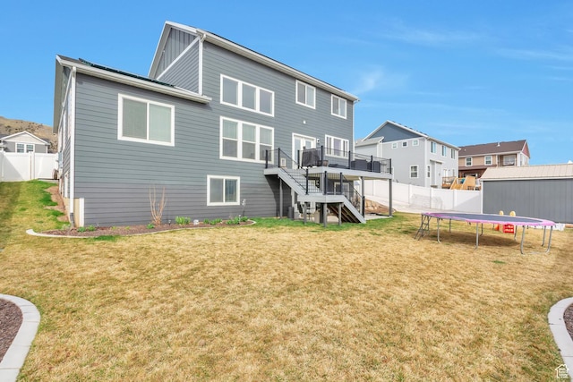 13907 S Birch Leaf W, Herriman, UT 84096 - rear view of house featuring stairs, a trampoline, a fenced backyard, a deck, and a lawn