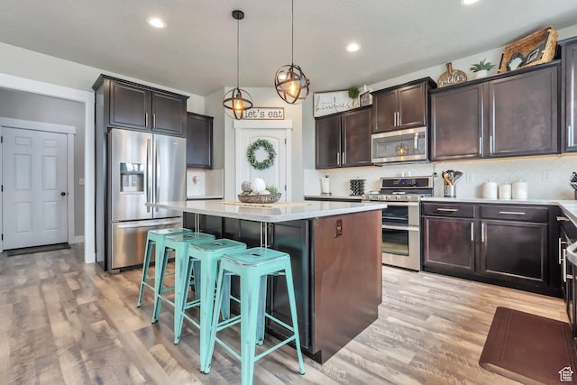 13907 S Birch Leaf W, Herriman, UT 84096 - kitchen featuring stainless steel appliances, light wood-style floors, a kitchen island, and tasteful backsplash