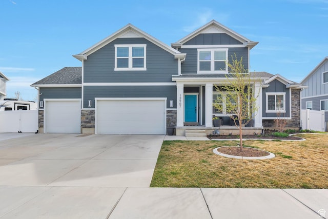 craftsman inspired home featuring driveway, stone siding, fence, board and batten siding, and a front lawn