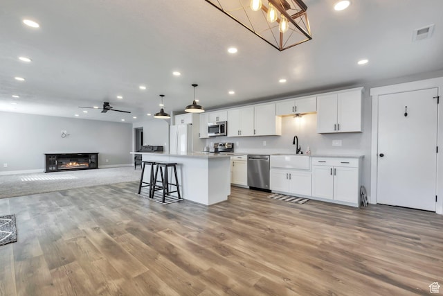 13907 S Birch Leaf W, Herriman, UT 84096 - kitchen with open floor plan, a center island, a sink, visible vents, and appliances with stainless steel finishes