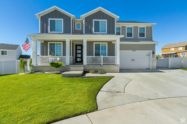 view of front of property featuring concrete driveway, fence, a front lawn, covered porch, and a garage