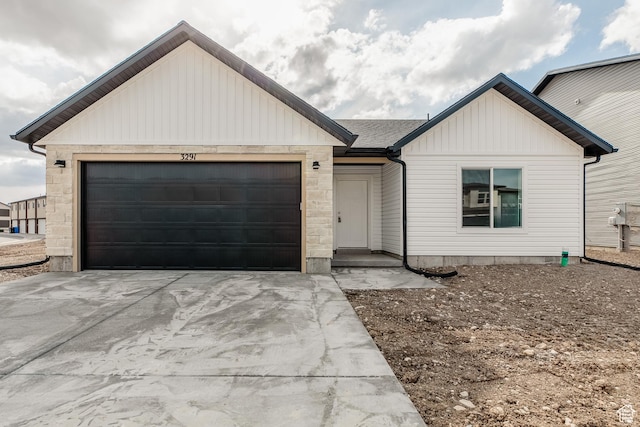 view of front of house with an attached garage, board and batten siding, and concrete driveway