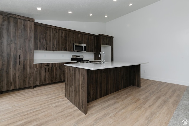 3291 S 1000 W, Nibley, UT 84321 - kitchen with vaulted ceiling, stainless steel appliances, modern cabinets, a kitchen island with sink, and dark brown cabinets