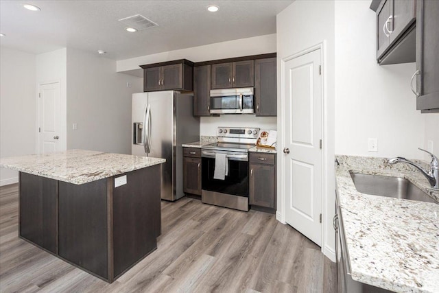 250 W 1200 S Unit 118, Tremonton, UT 84337 - kitchen with dark brown cabinetry, light wood finished floors, a sink, and appliances with stainless steel finishes