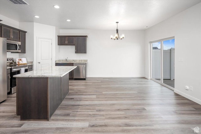 250 W 1200 S Unit 118, Tremonton, UT 84337 - kitchen with dark brown cabinetry, light wood-style flooring, stainless steel appliances, and an inviting chandelier