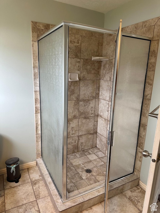 706 S 1690 W, Logan, UT 84321 - bathroom featuring a stall shower, baseboards, and stone finish flooring