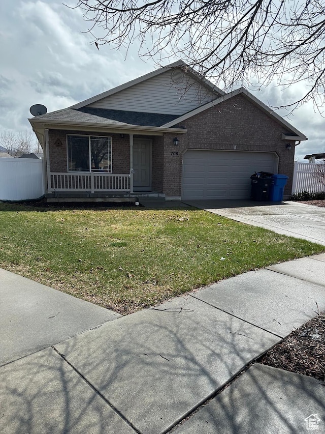 706 S 1690 W, Logan, UT 84321 - view of front of house with brick siding, a front yard, concrete driveway, and fence